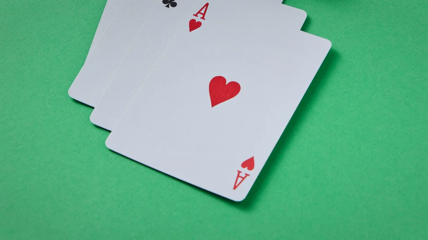 Three aces fanned out on the felt